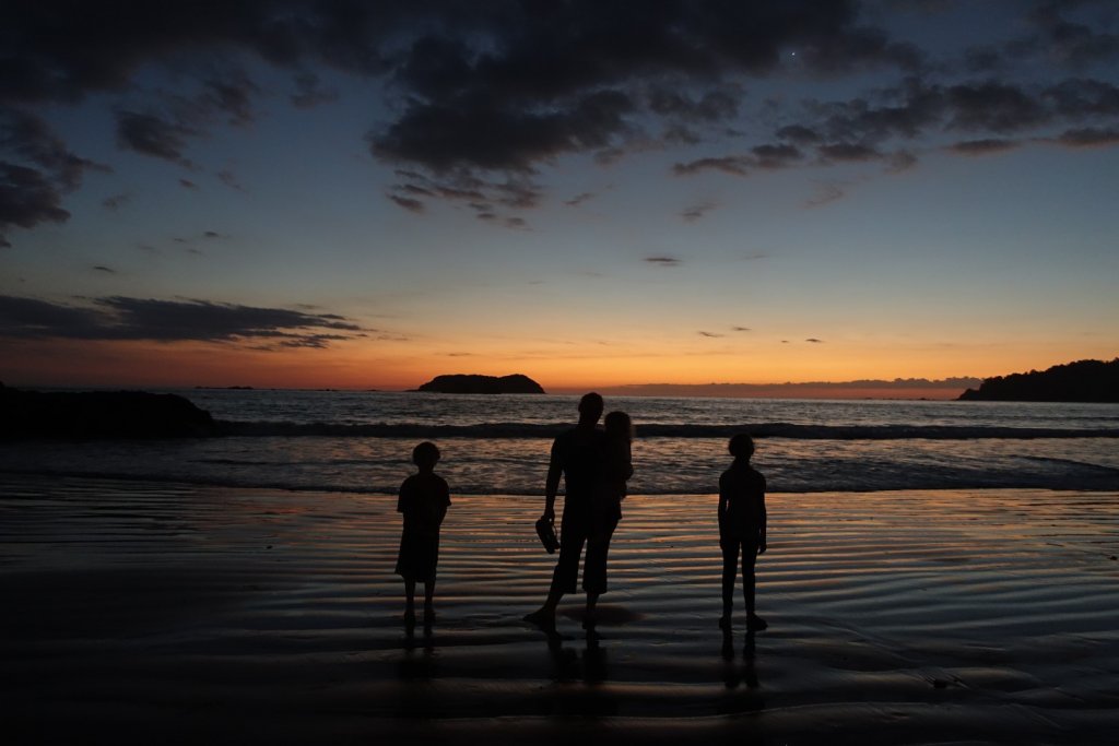 standing on the beach at sunset