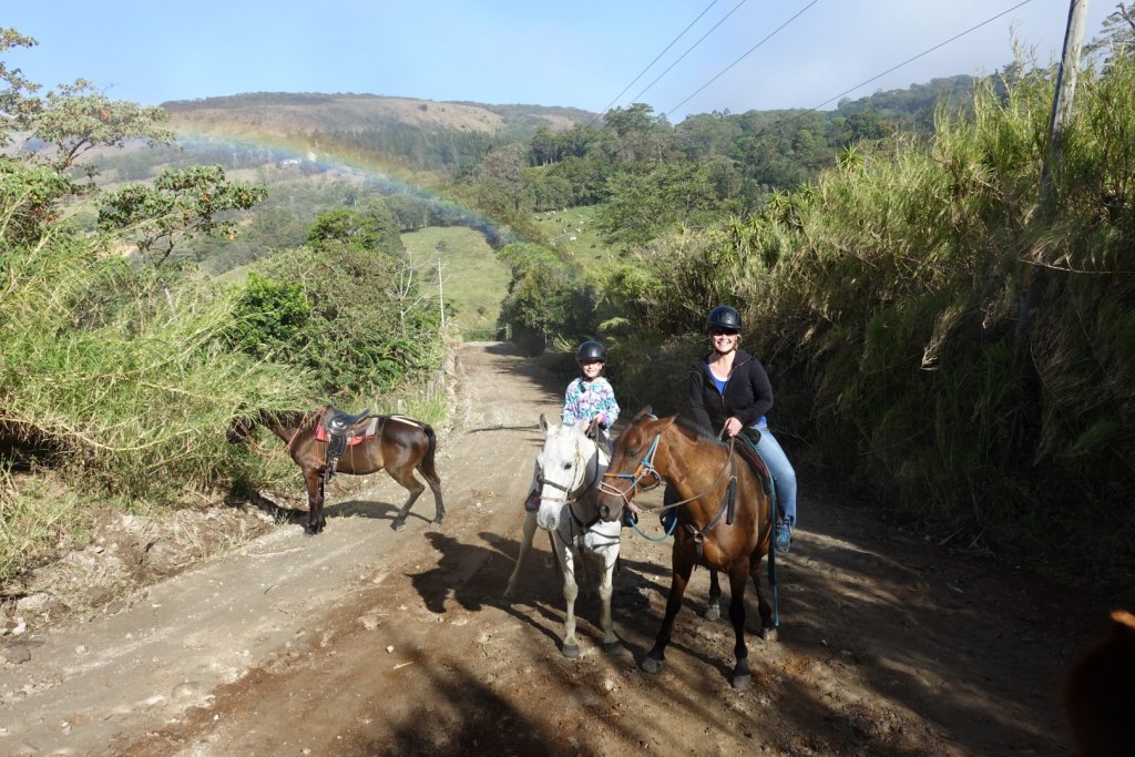 Riding horses with a rainbow in the backround