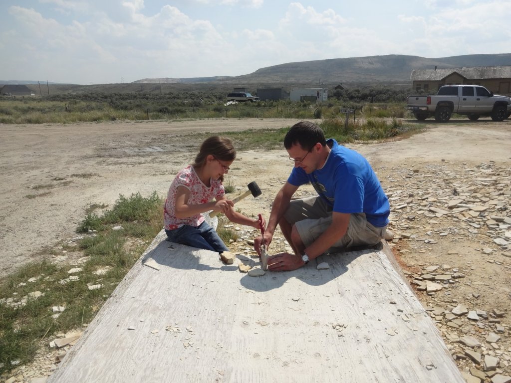 father and daughter splitting fossil rock