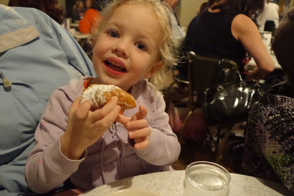 girl eating a beignet