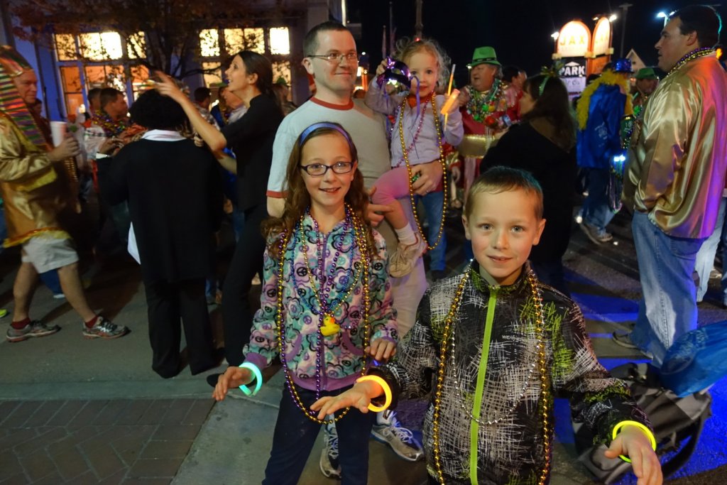 family with necklaces and light up trinkets from parade