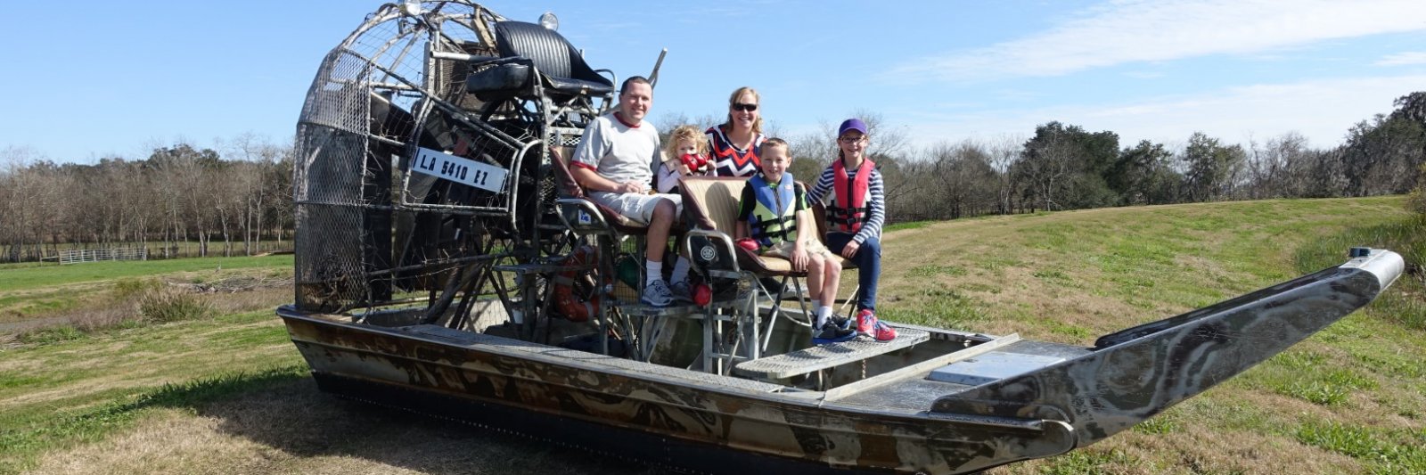 family sitting on an airboat