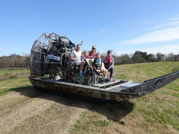 family sitting on an airboat