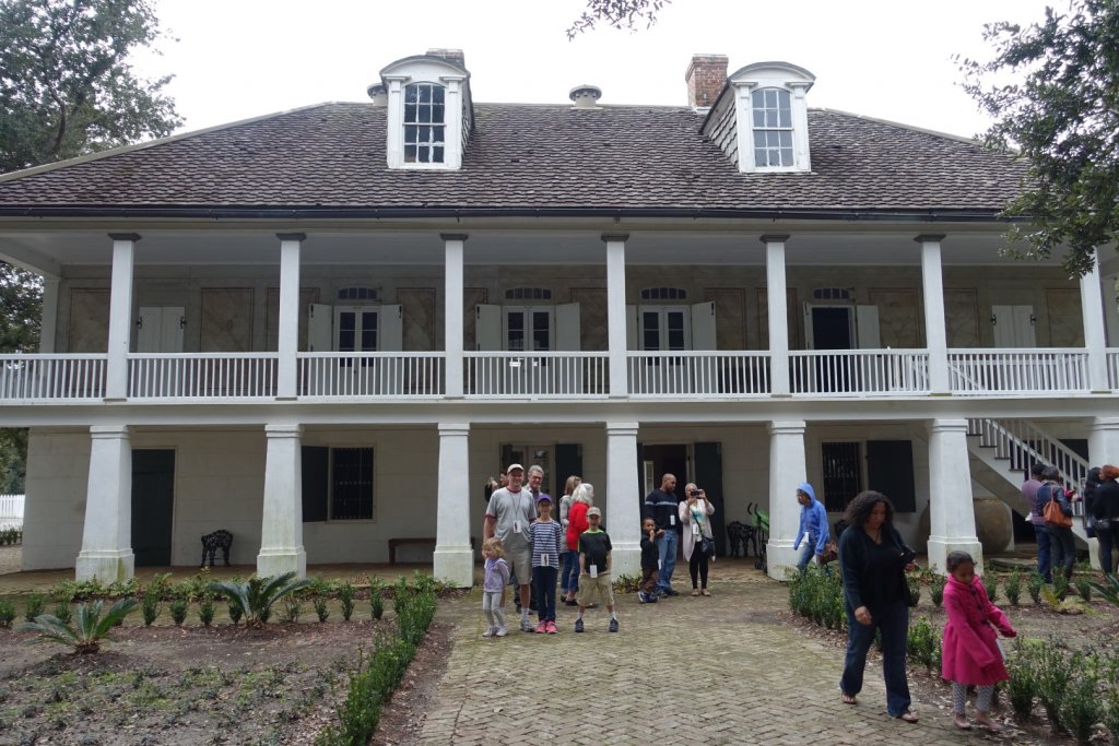 family in front of old slave plantation