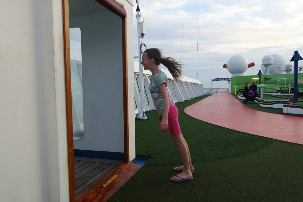 girl leaning into the wind on a cruise ship