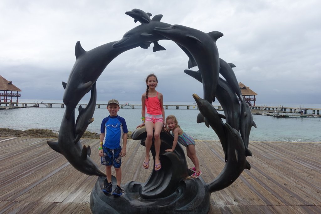 kids on a dolphin sculpture