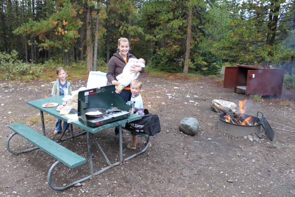 mom and kids with campfire and campstove