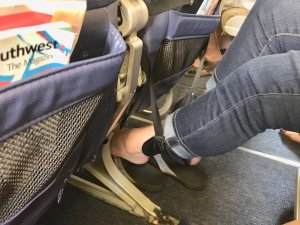 feet up in a foot hammock on an airplane