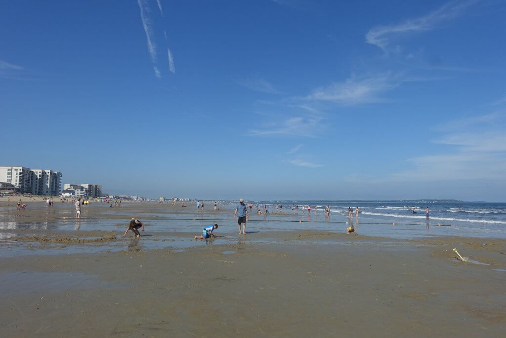 people playing in the sand on the beach