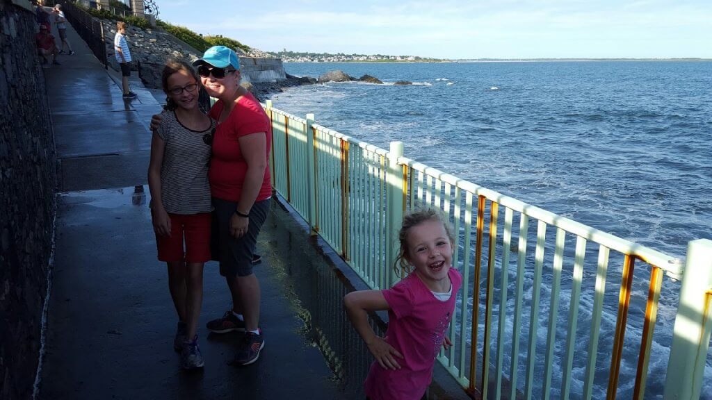 mother and two daughters on path by the ocean