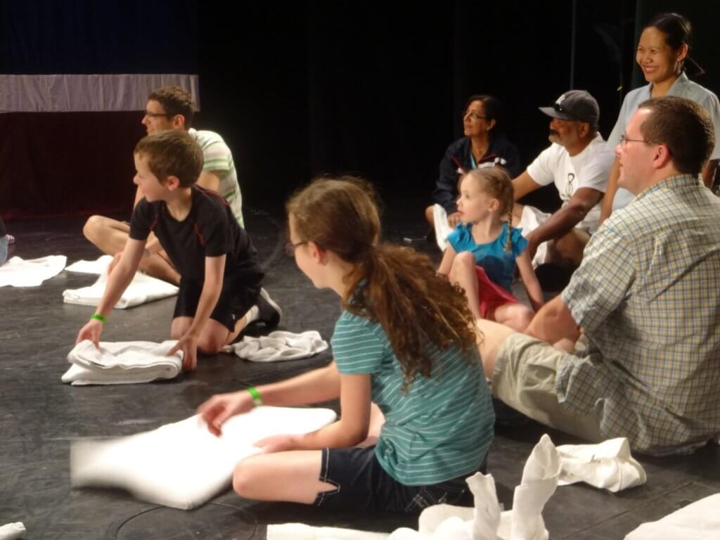 people learning to fold towels into animals