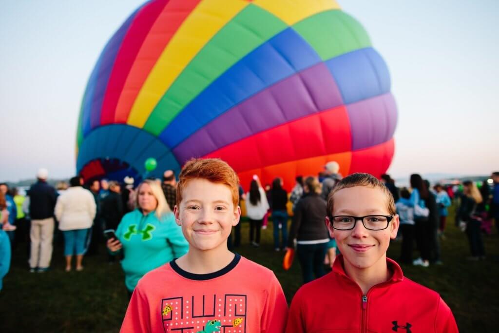 two boys in in front of hot air balloon inflating