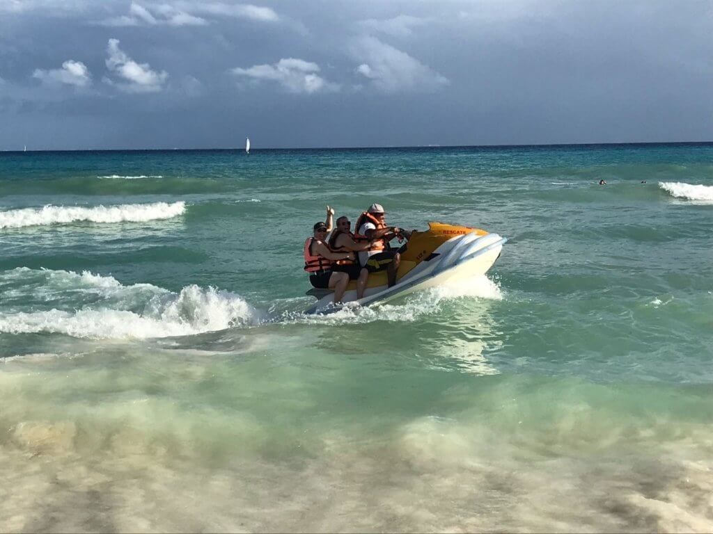 three people on a jet ski in the ocean