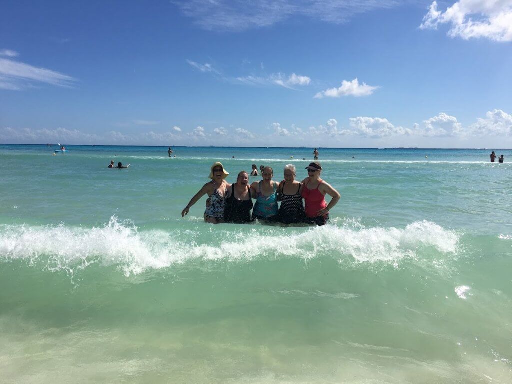 women laughing in the ocean