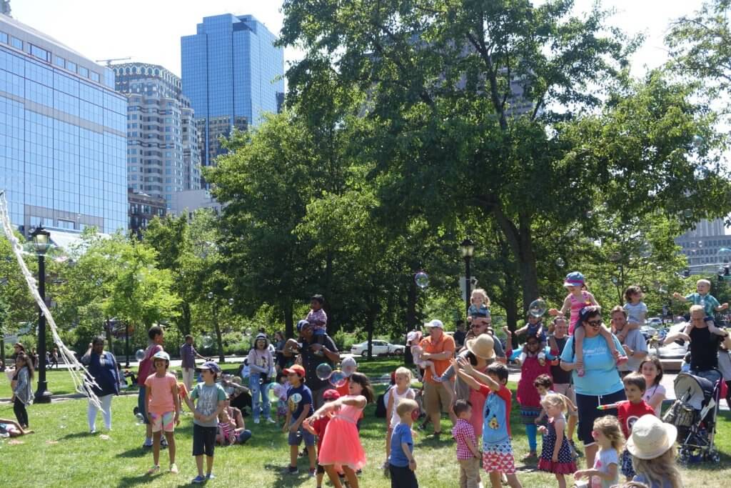 kids playing with bubbles in a park