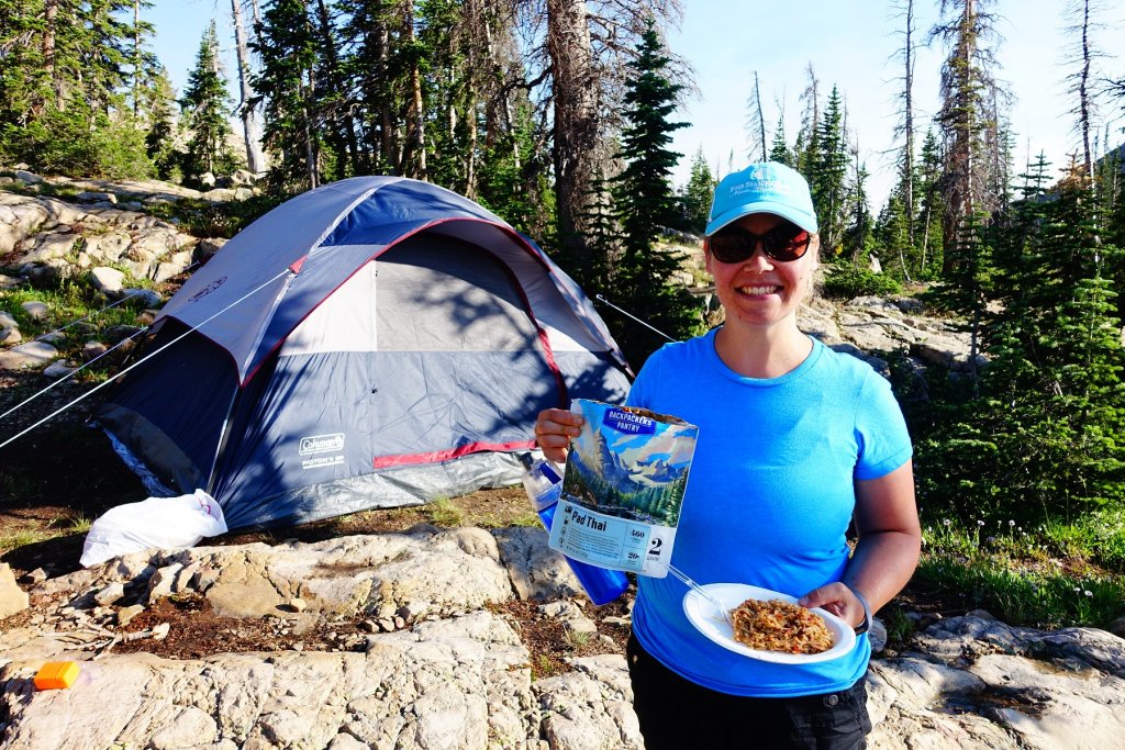 woman with food in front of a tent