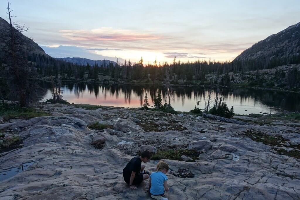 boy and girl on a large rock with lake