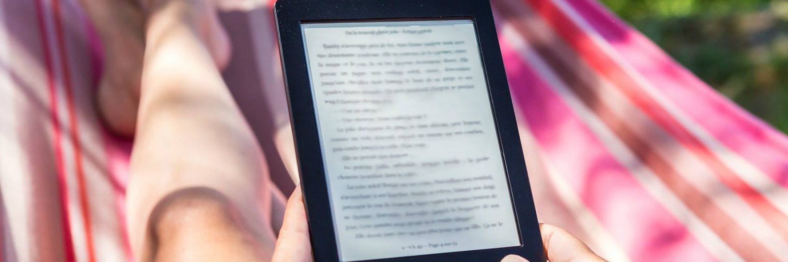 person reading from a tablet on a hammock