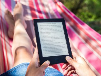 person reading from a tablet on a hammock