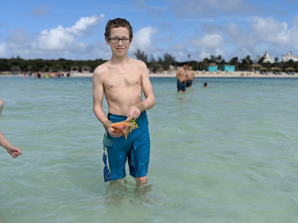 boy with shell in the ocean