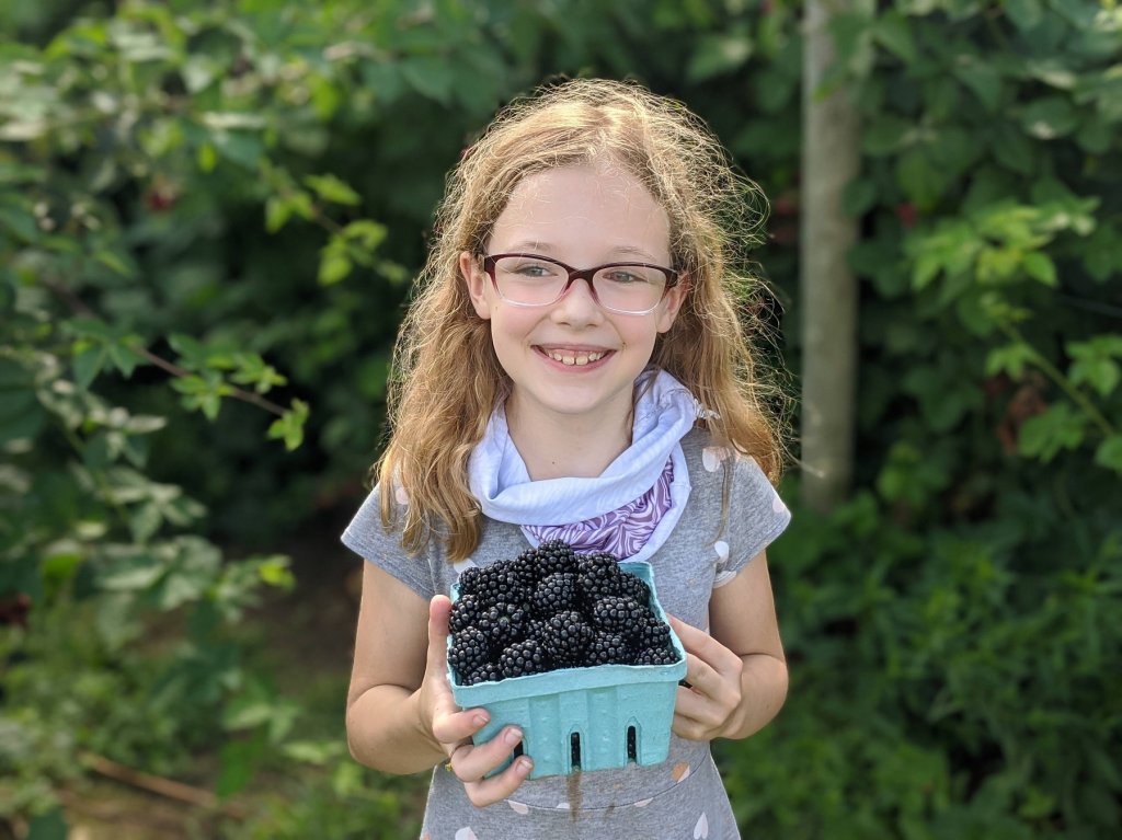 girl holding fresh blackberries