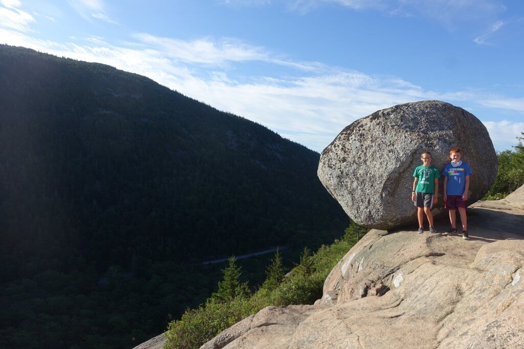 two boys in front of rock