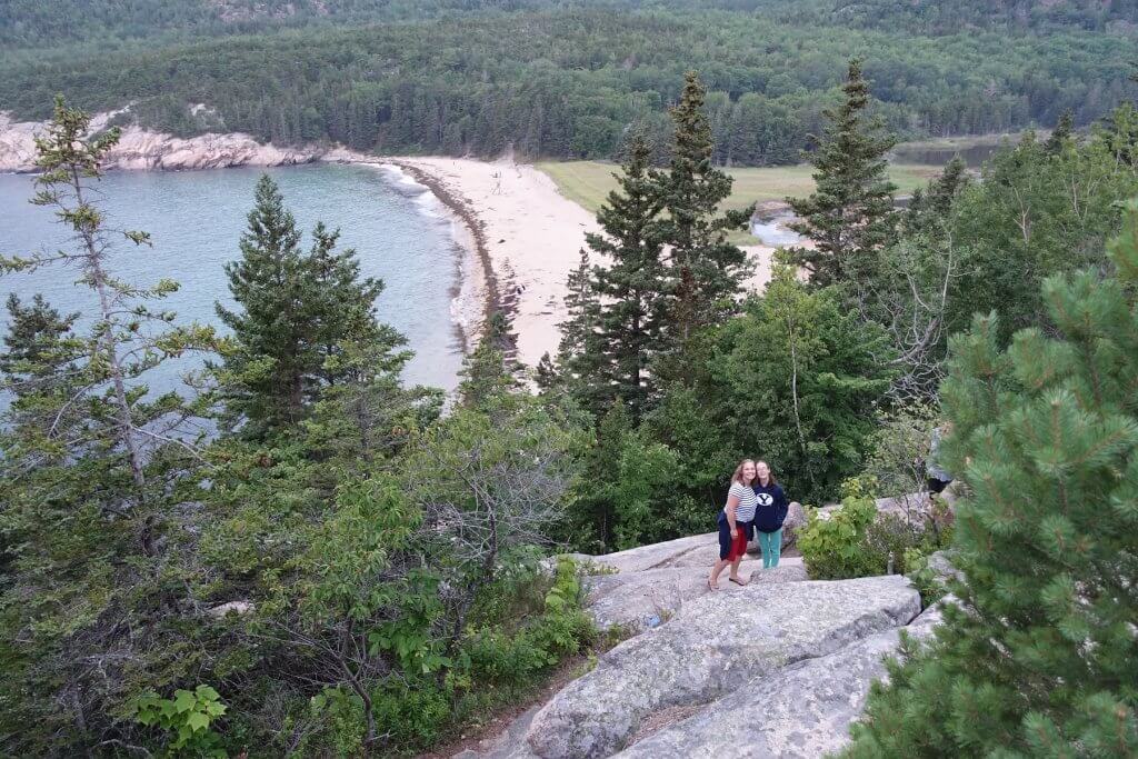 mom and daughter on hike with beach in background