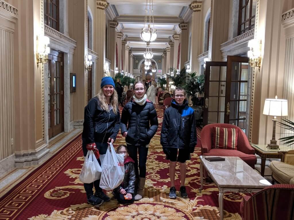 mom and kids with groceries in hall