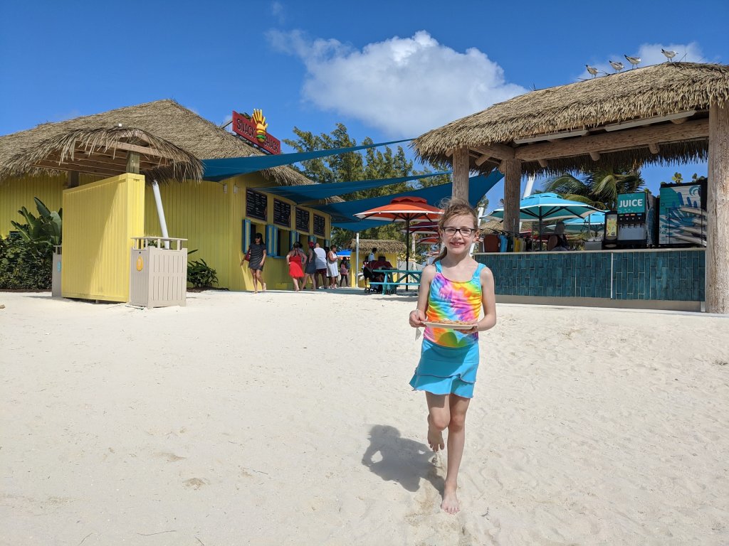 girl with plate of food on the beach