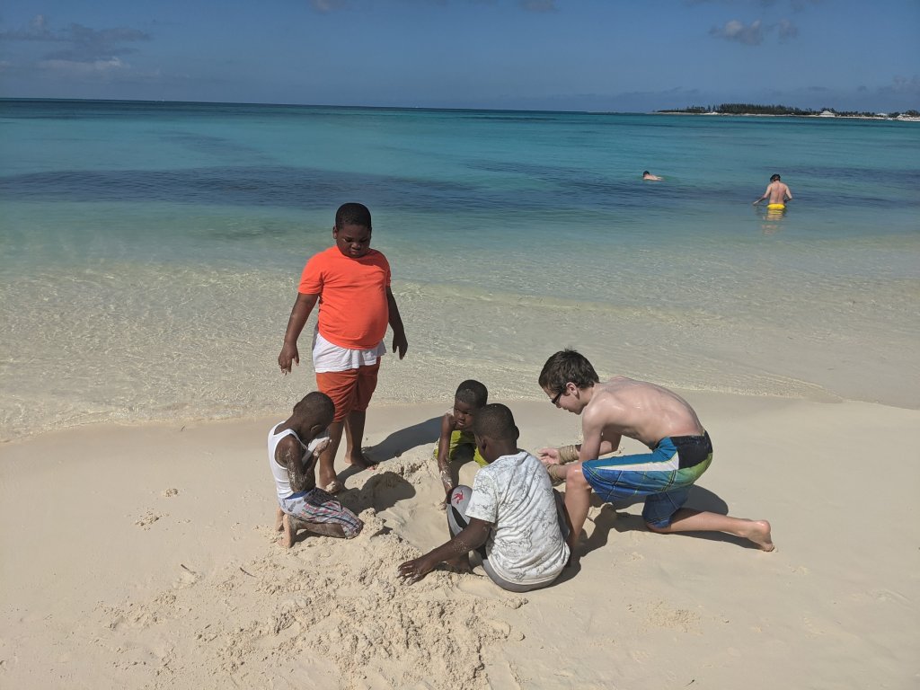 boys digging in the sand on beach