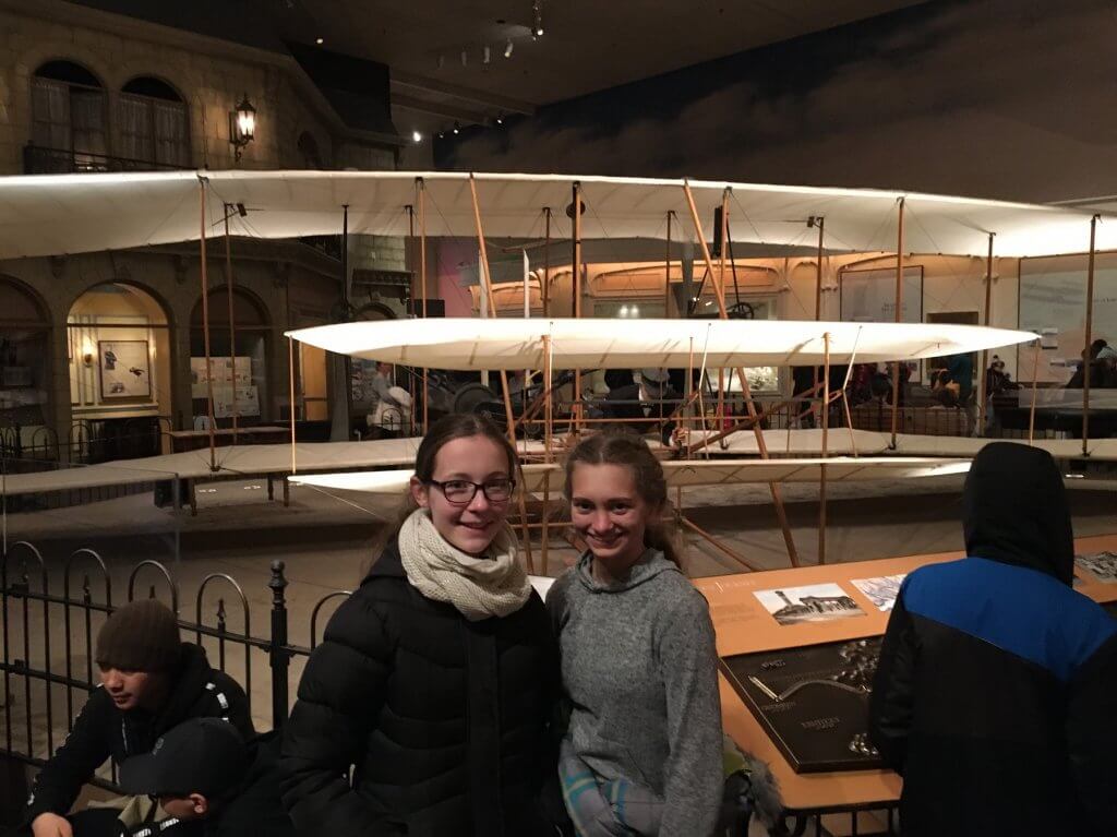 girls in front of airplane display at museum