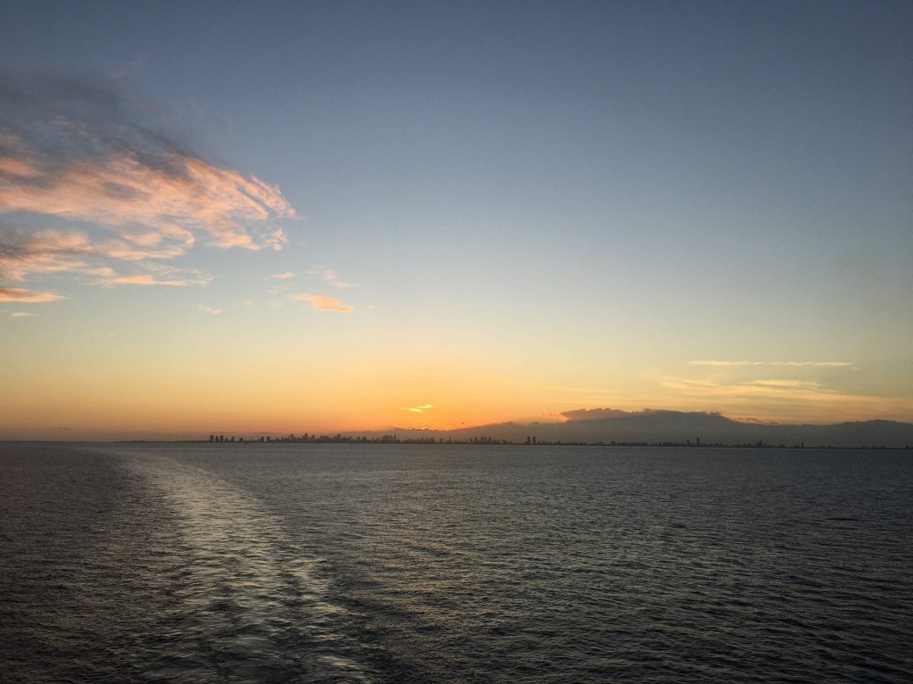 Sunset over city from the ocean