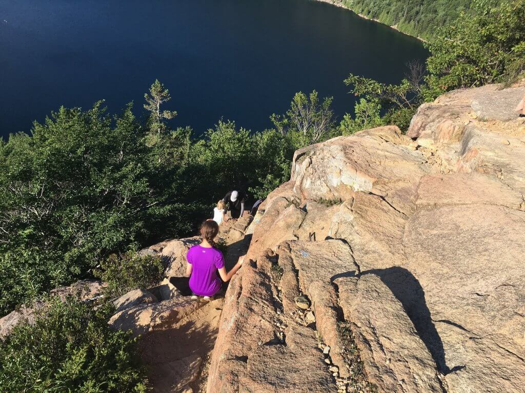 people climbing down rocks