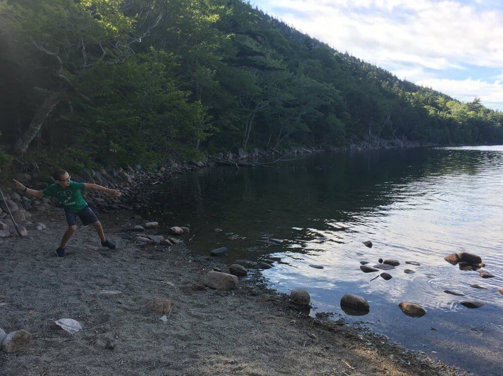 boy throwing rock in water