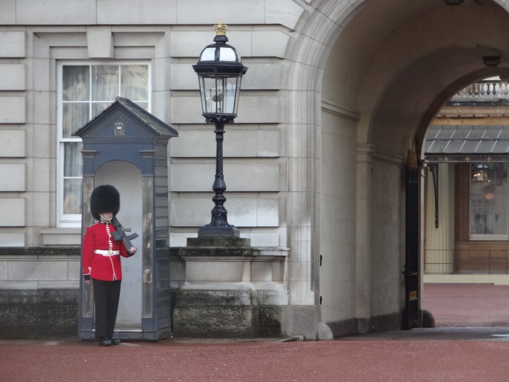 guard wearing red coat and tall black hat