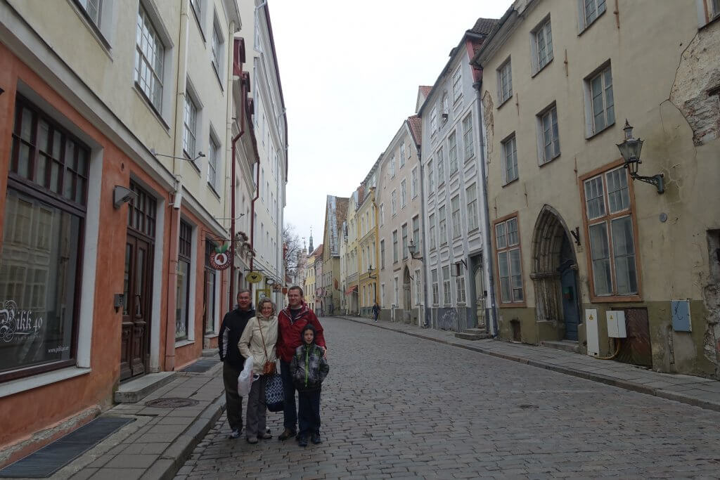 four people standing in street of old town