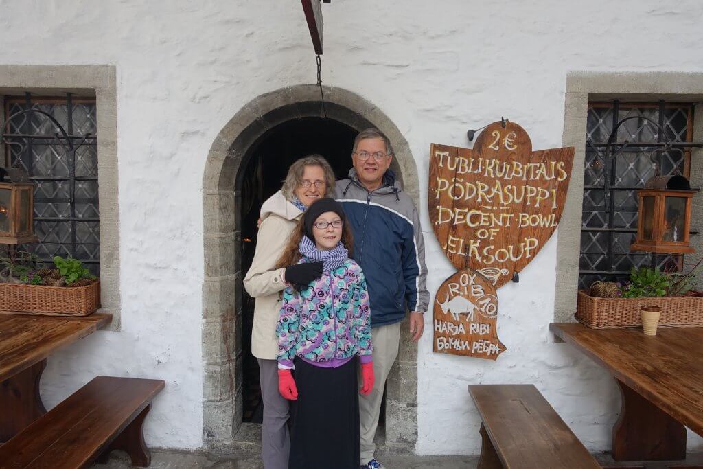 man, woman, and child in front of arched door