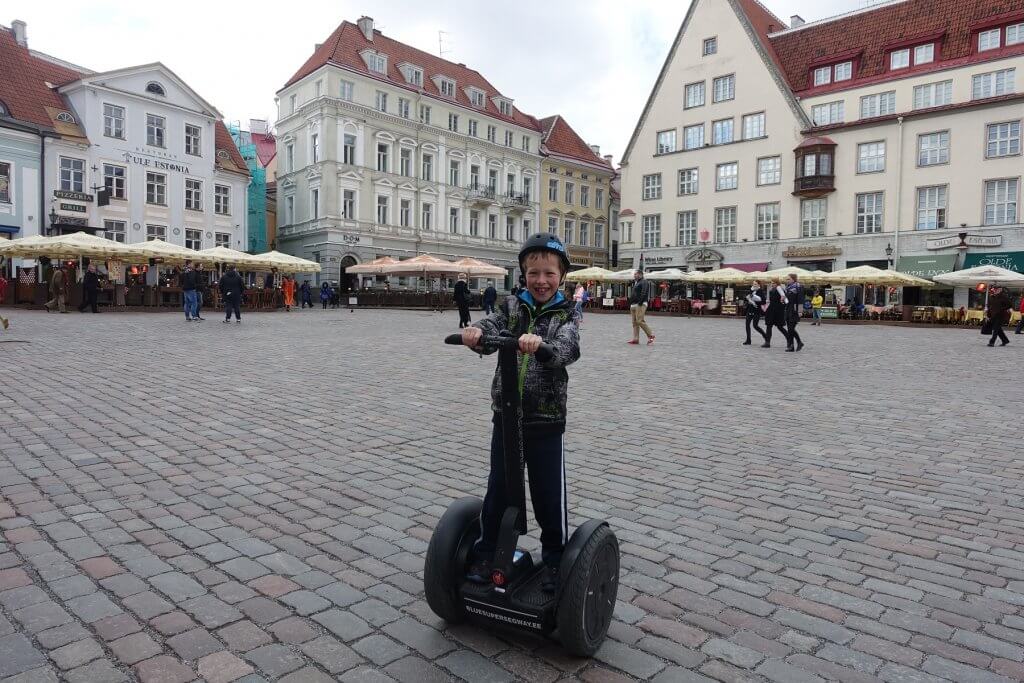 boy riding a Segway on cobble street