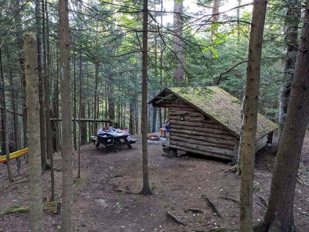 boy sitting at campground near lean to