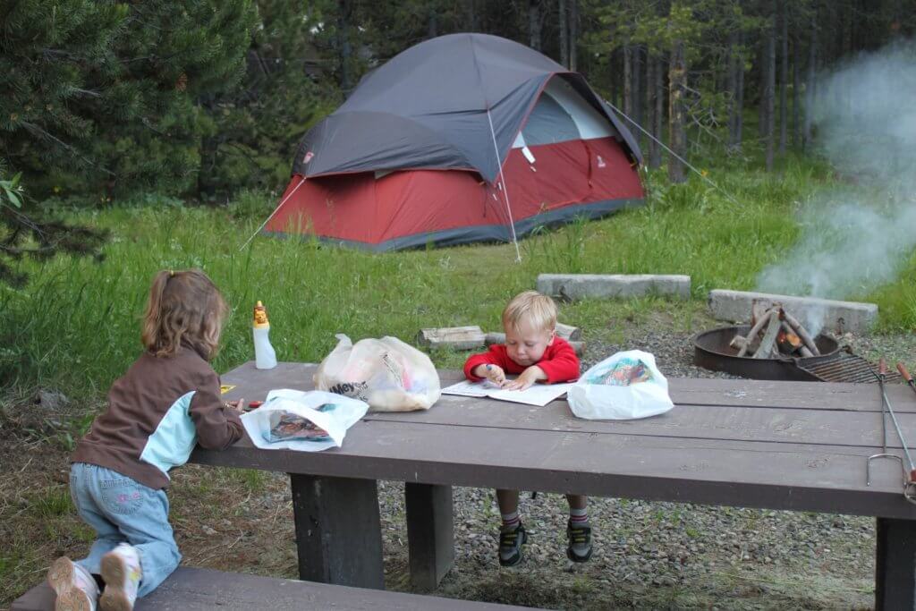 Boy and girl at picnic table at campsite