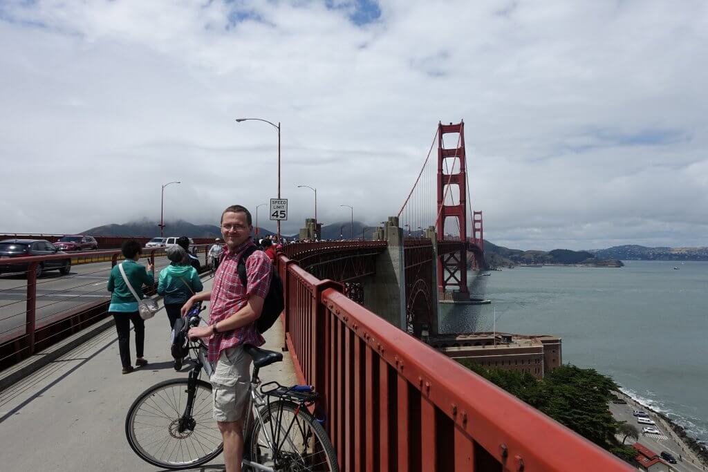 man on bridge with bike