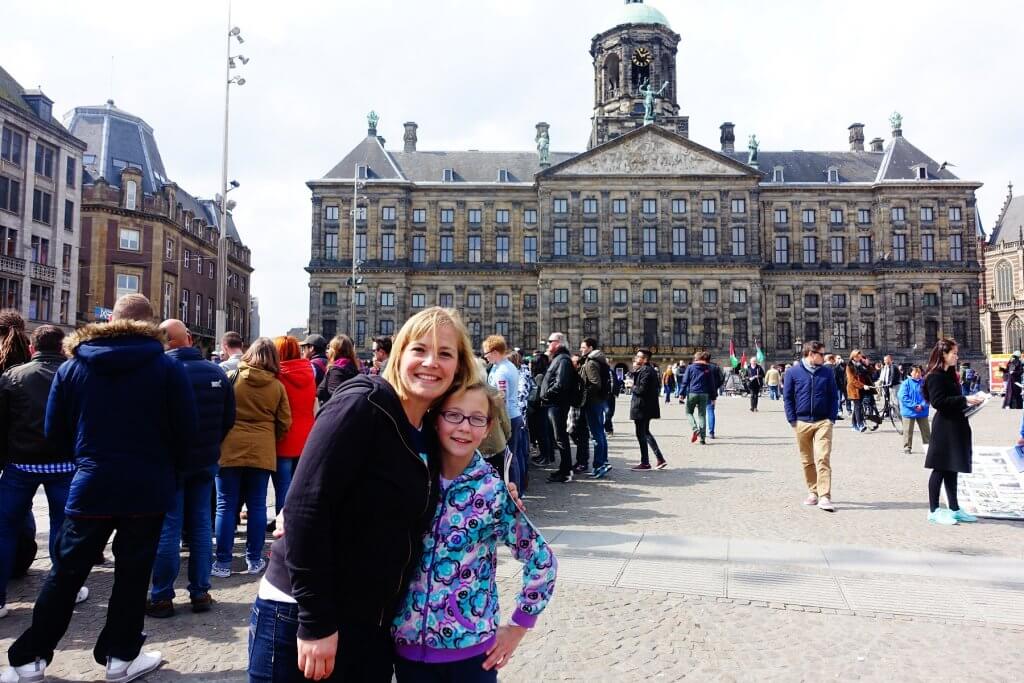 mom and daughter in front of old building