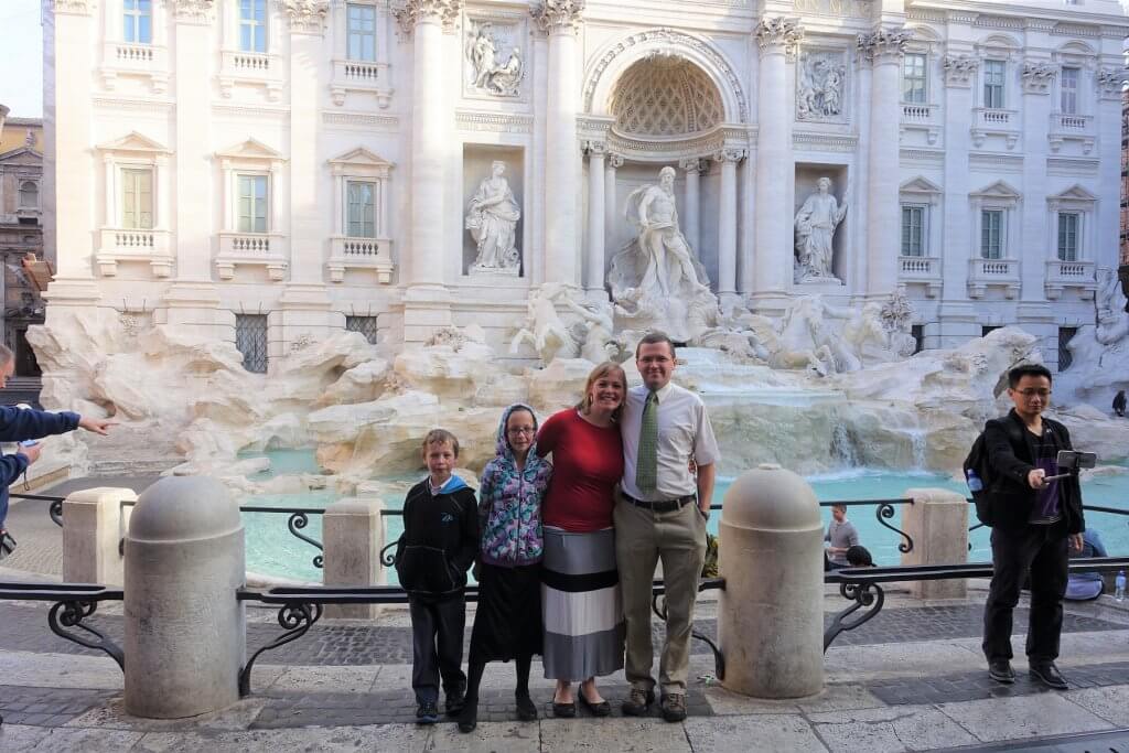 family in front of fountain with sculptures