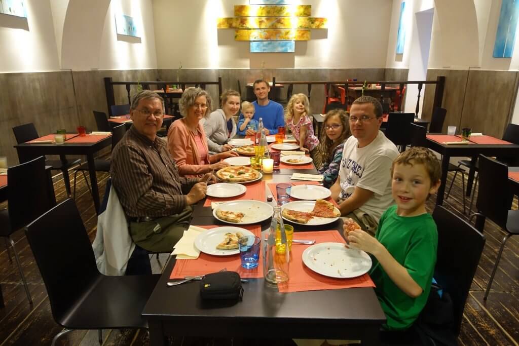 family eating pizza at long table