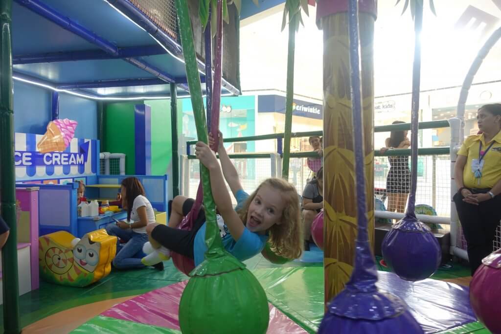 girl hanging on colored ropes