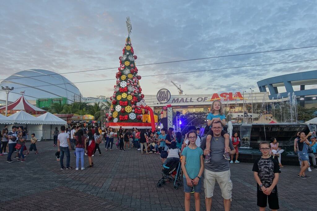 famkiy in front of mall with Christmas tree