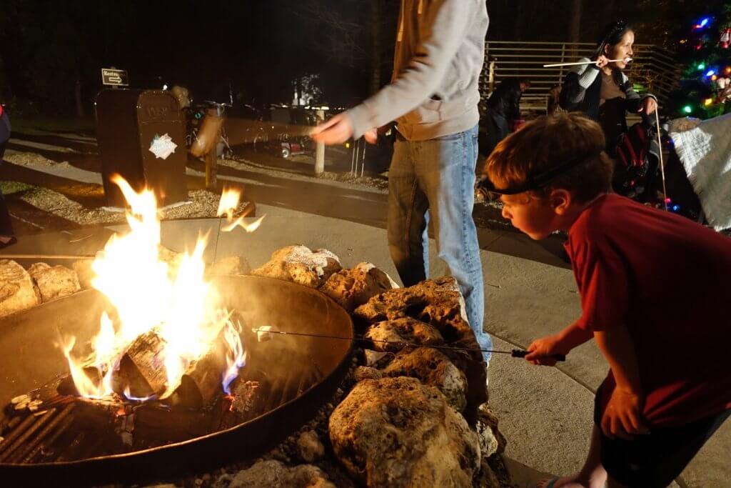 boy roasting a marshmallow at campfire