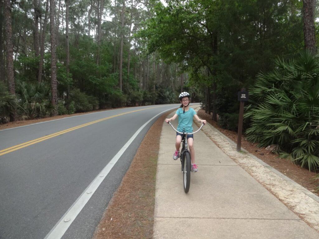 girl on a bike on sidewalk