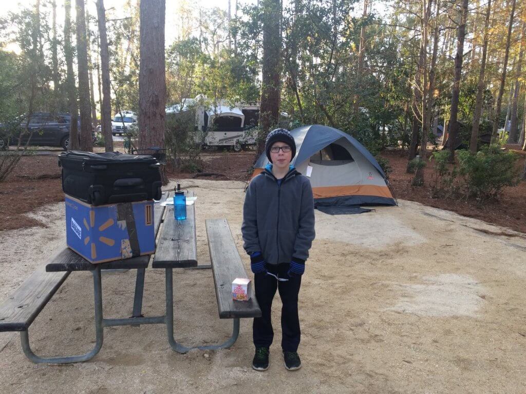 boy in hat in front of a tent