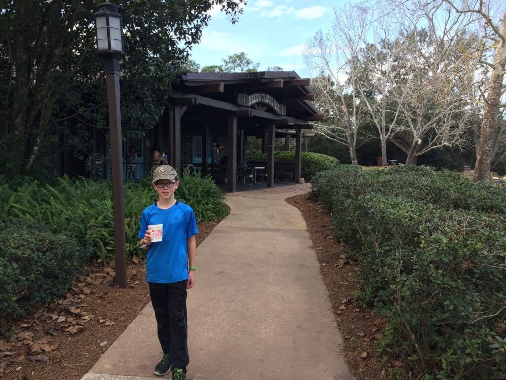 boy with cup on sidewalk